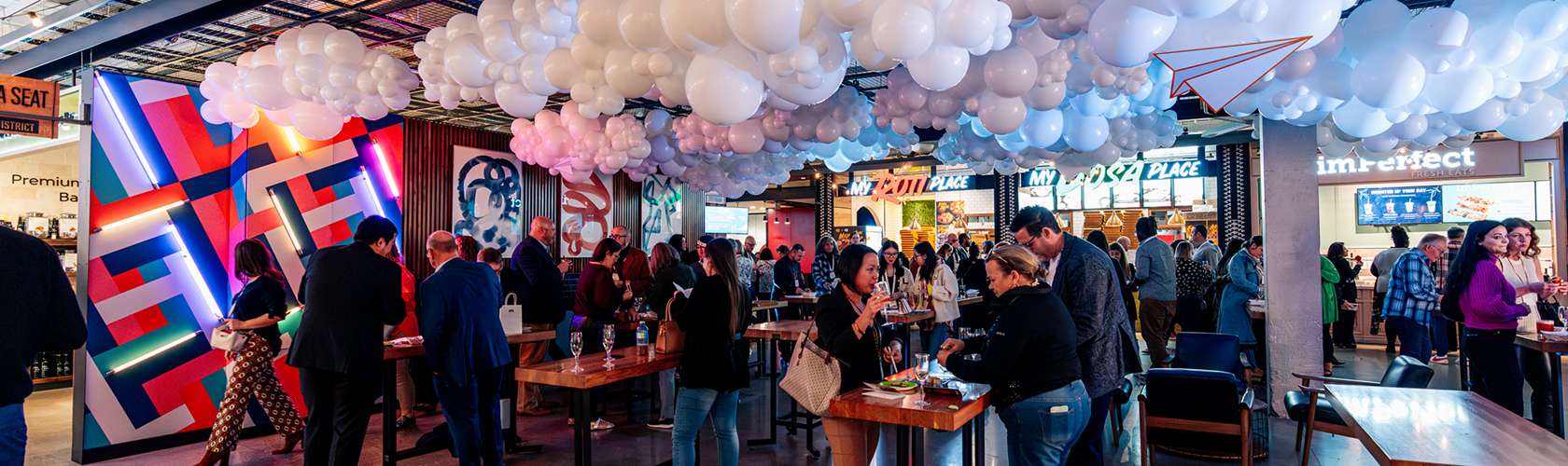 Guests enjoying a business event at the Food District with dining and social gathering spaces