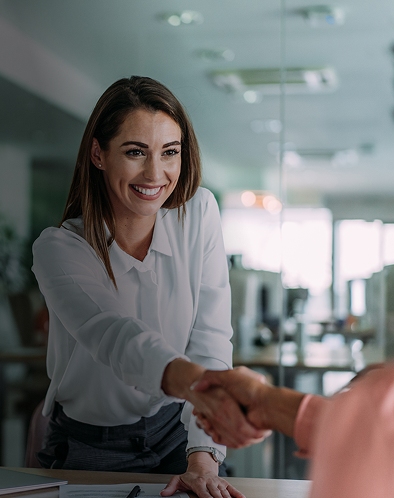 Professional thanking a client with a handshake while presenting a thoughtful gift card gesture