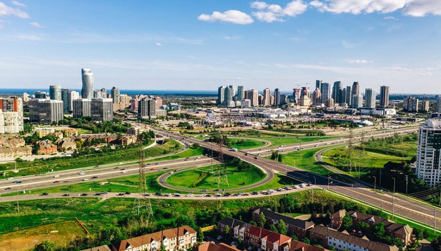 City skyline with a major highway highlighting convenient access to a nearby shopping destination