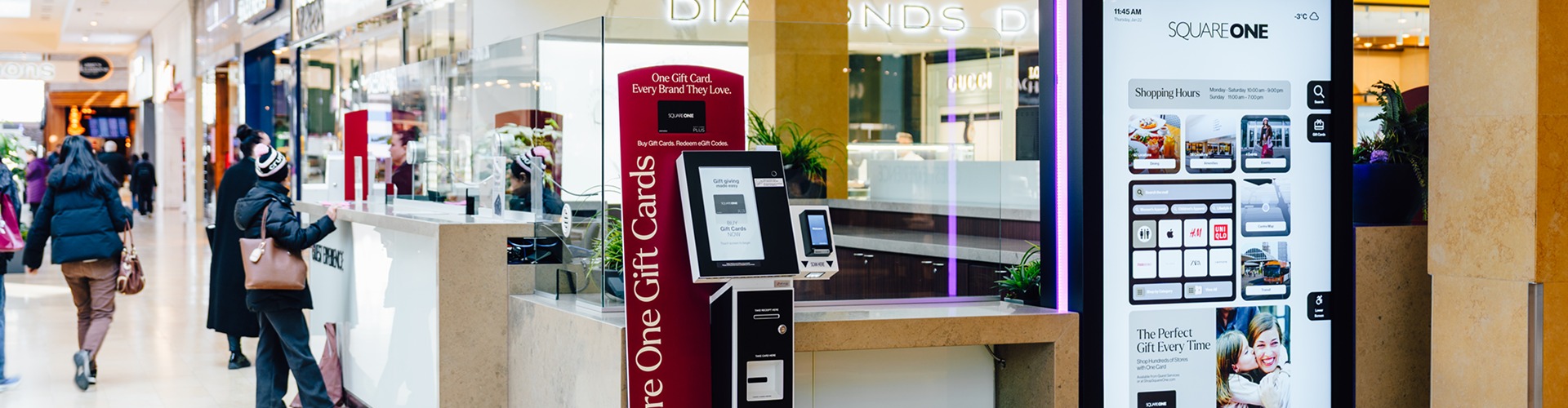 Gift card kiosk and digital mall directory at Square One shopping centre with shoppers nearby