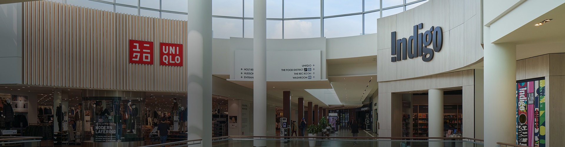 Retail corridor featuring Uniqlo and Indigo storefronts with clearly visible directory signage