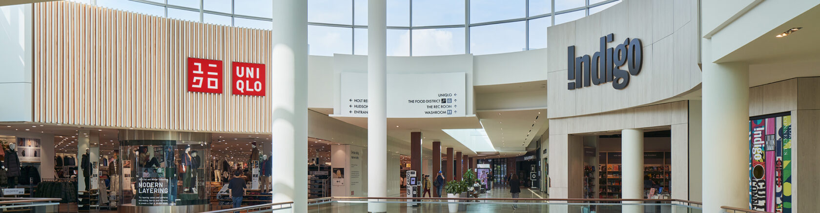 Retail corridor featuring Uniqlo and Indigo storefronts with clearly visible directory signage