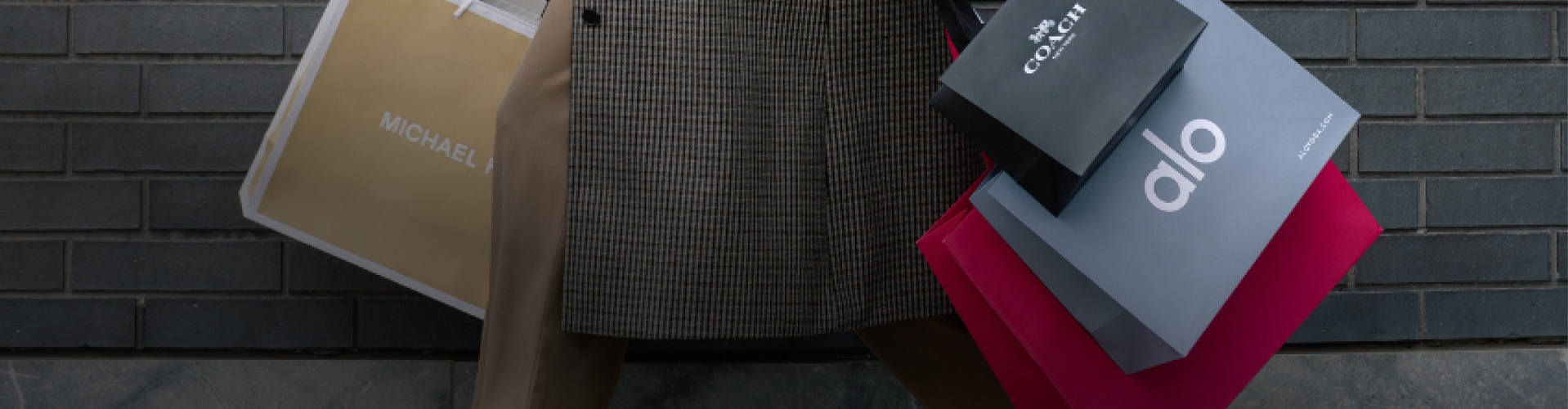 Michael Kors Coach and Alo shopping bags highlighting birthday offers and special deals