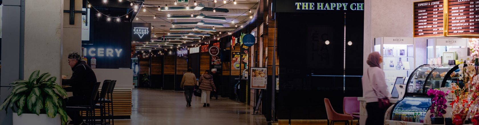 People exploring the Food District with multiple eateries offering a variety of dining options
