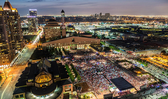Public square filled with a large crowd gathering for events, celebrations, and concerts at night