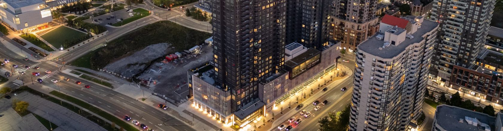 Aerial view of a busy shopping district with modern buildings and vibrant city streets lit at night