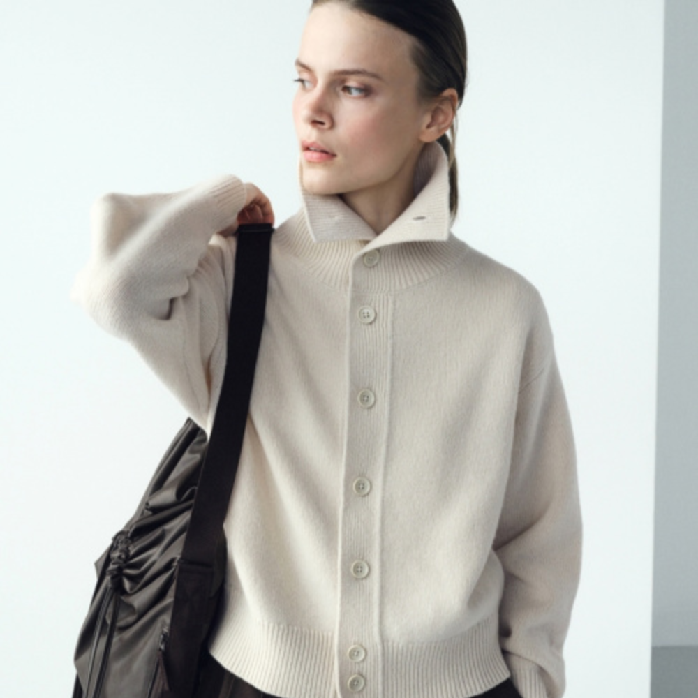 A woman wearing a high neck cardigan